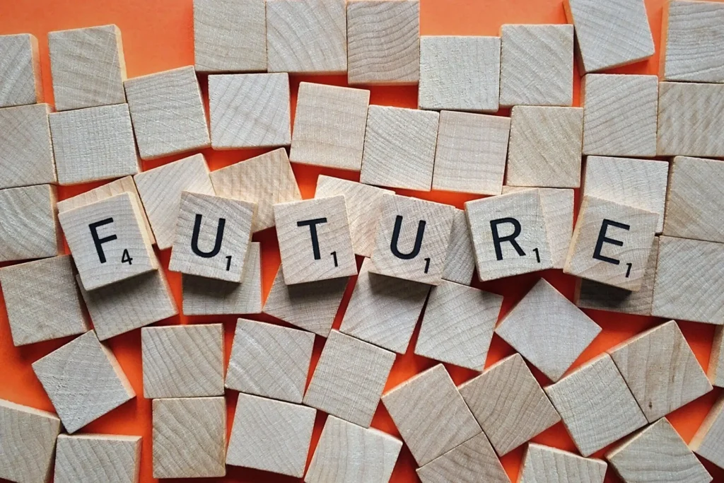 27 DiGi AI Art vs Human Art : The Ultimate Creative and Innovative Showdown 5 Scrabble tiles spell "FUTURE" on an orange background, surrounded by blank wooden squares.