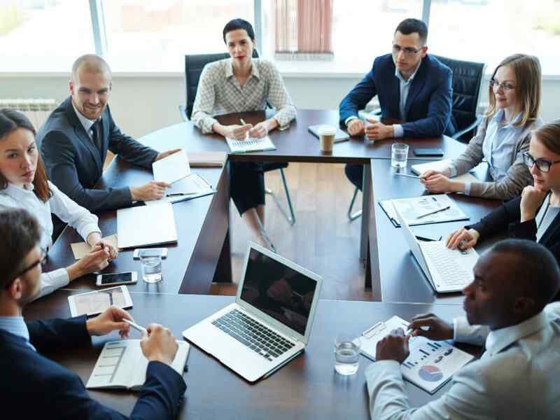 Image 15 Several People Sitting At a Table Discussing And Sharing Ideas